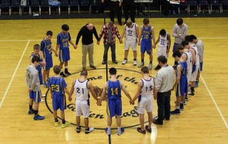 Boy's basketball team prays before game